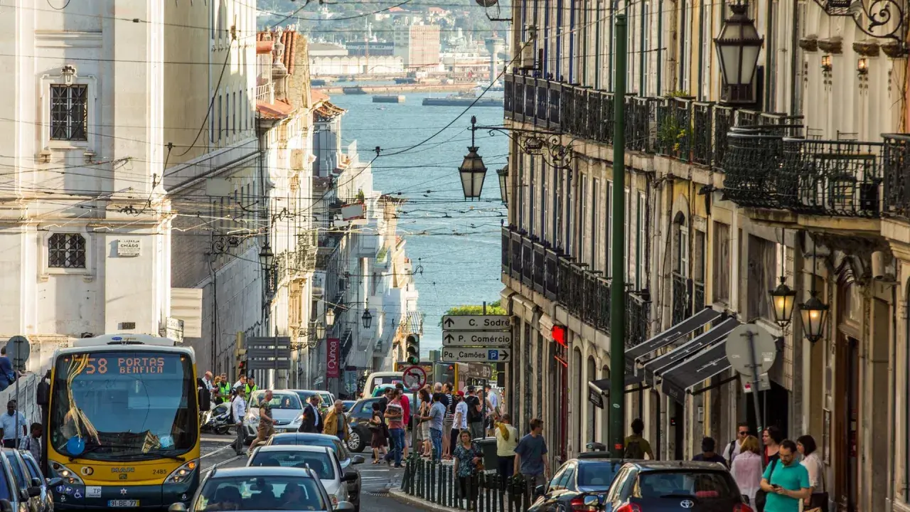 Ein belebter Tag in Lissabon, wo die portugiesischen Einwohner die engen Gassen mit ihren historischen Gebäuden und dem Blick auf das Wasser beleben.