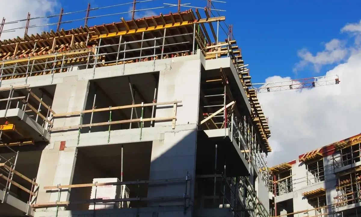 Rohbau eines Mehrfamilienhauses im Rahmen der Entwicklung von urbane gebiete. Gerüste und Betonstrukturen unter blauem Himmel.