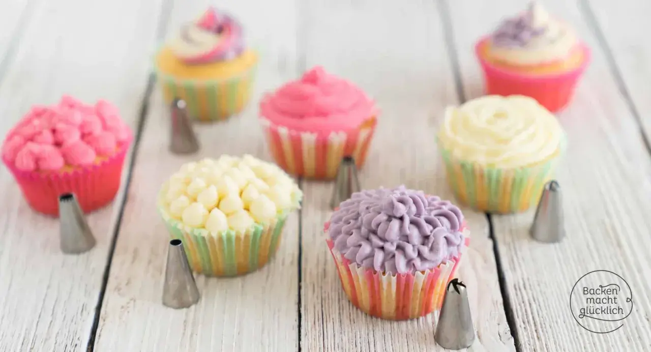 Bunte Muffins verzieren: Rosa, gelbe und lila Frosting-Kreationen mit Spritztüllen.