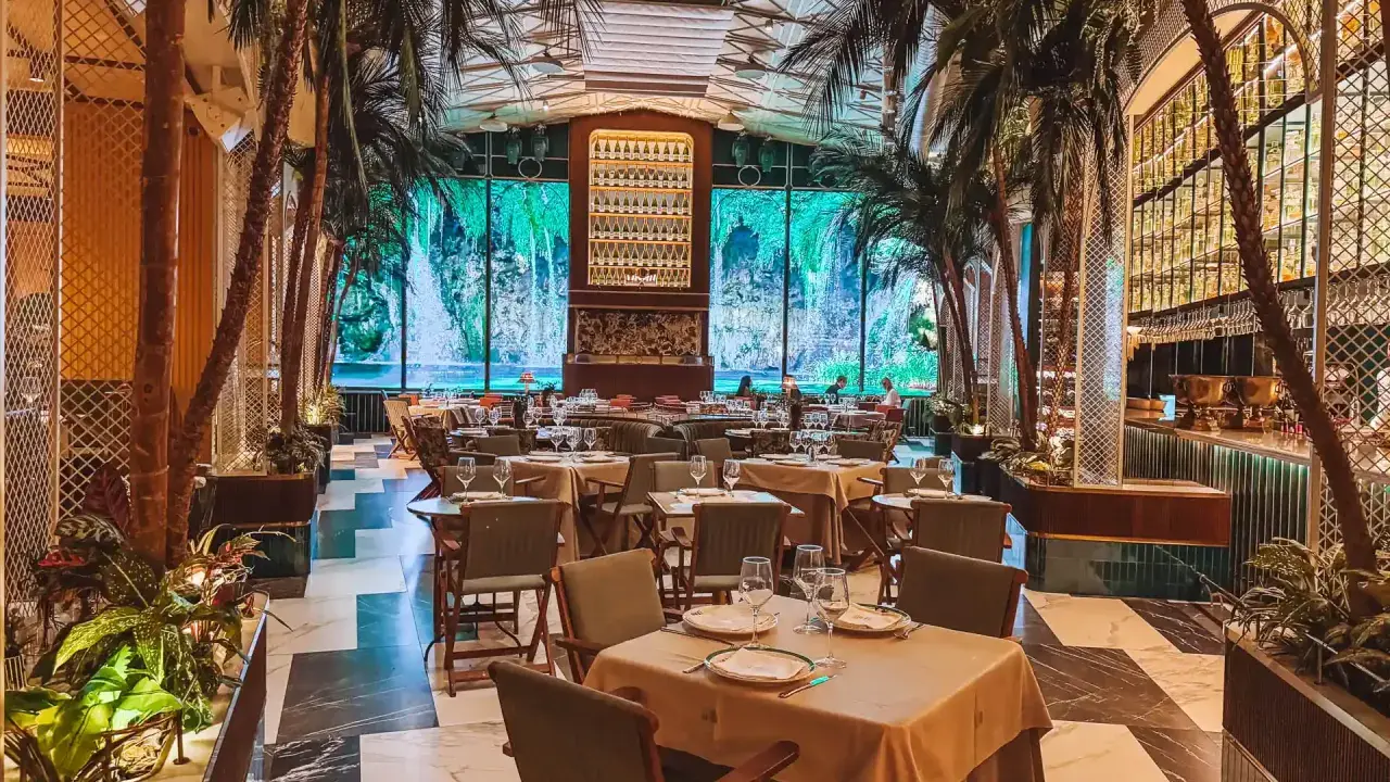 Tropische Atmosphäre in einem der Restaurants in Valencia. Palmen und ein Wasserfall-Bild im Hintergrund schaffen ein einzigartiges Ambiente.