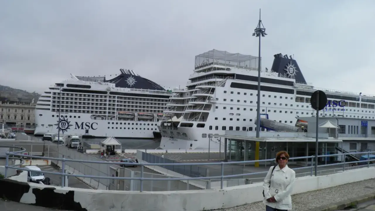 Donna in piedi davanti a due navi MSC in attesa dell'imbarco a Genova per Portofino.