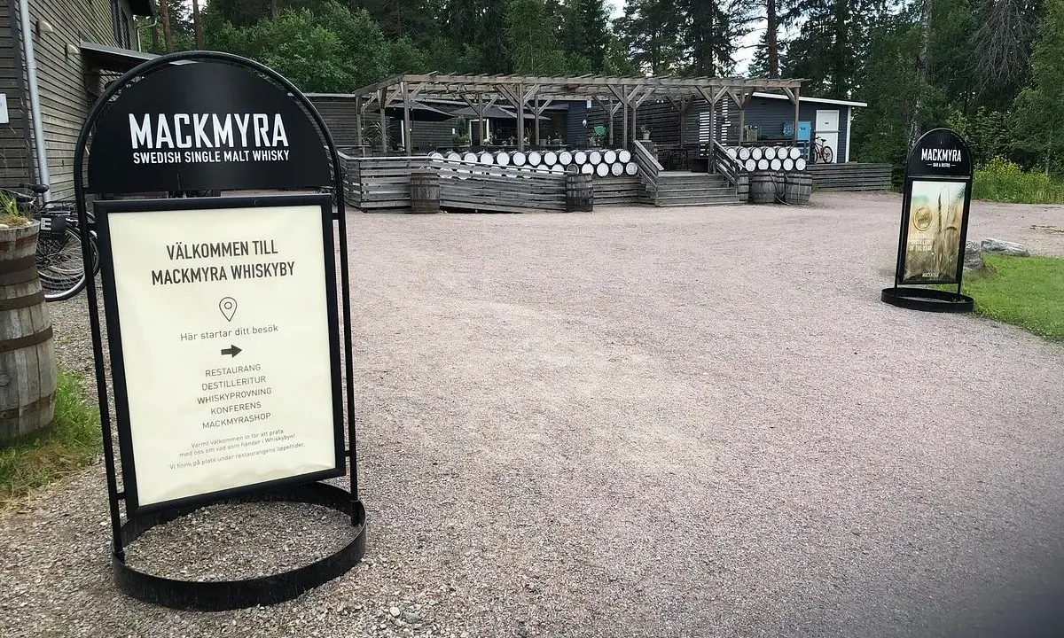 Välkommen till Mackmyra whiskyby! Skylten visar vägen till restaurang, destilleritur och whiskyprovning på Mackmyra destilleri.