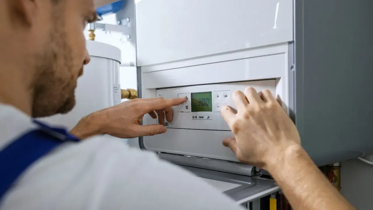 Un technicien ajuste les réglages d'une chaudière fioul qui démarre puis s'arrête.