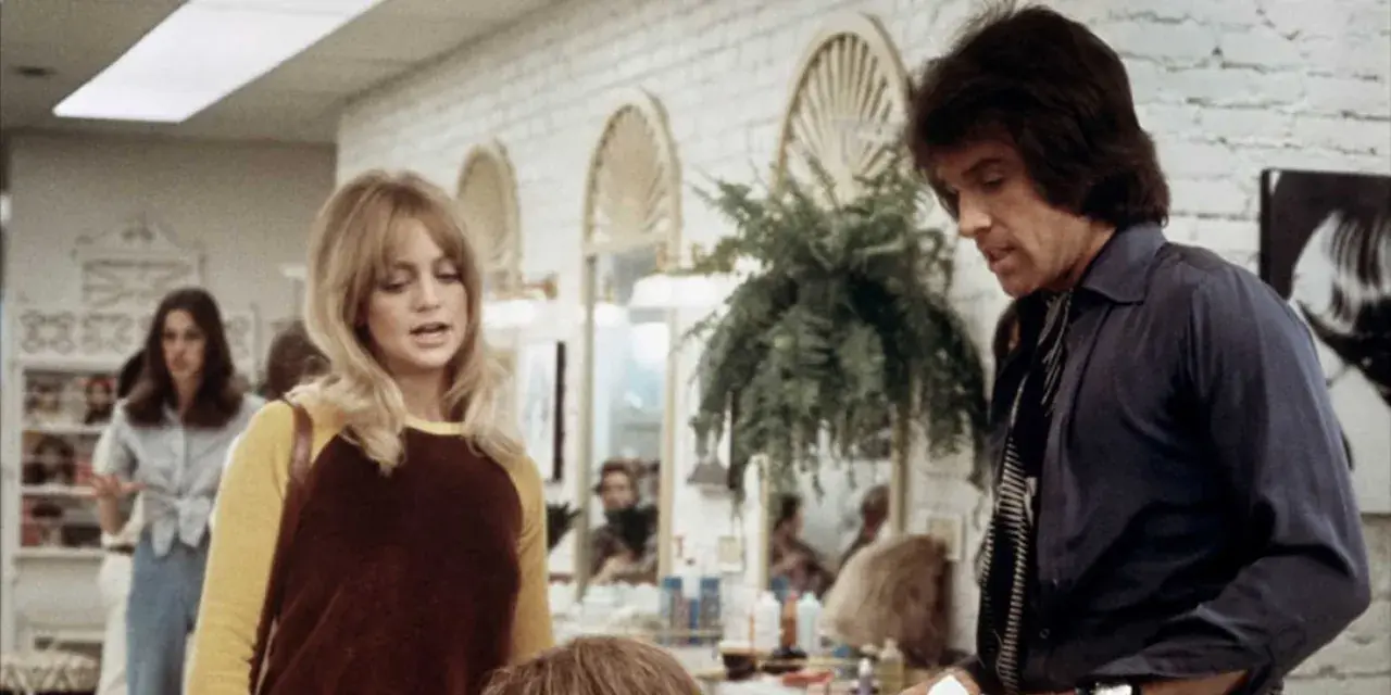 Goldie Hawn och Warren Beatty i en scen från en film. Hon har blont hår och en gul och brun tröja. Han har mörkt hår och en mörk skjorta.