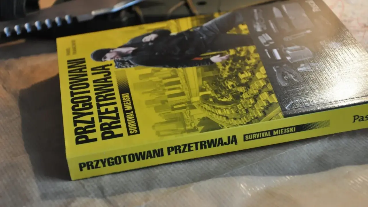 Książka "Przygotowani przetrwają. Survival miejski" leży obok noża. Podręcznik do przetrwania w miejskiej dżungli.