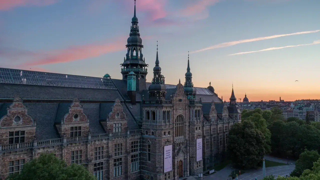 Nordiska museet badar i solnedgångens rosa sken.