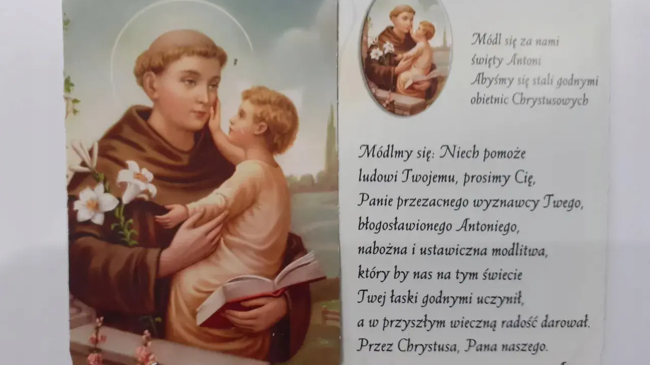 Święty Antoni z Dzieciątkiem Jezus, otoczony kwiatami lilii. Obok tekst modlitwy do świętego Antoniego.