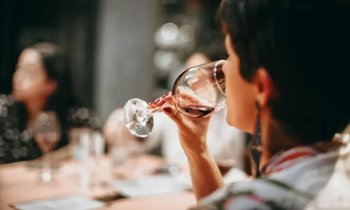 Mujer disfrutando de diferentes tipos de vino en una cata.