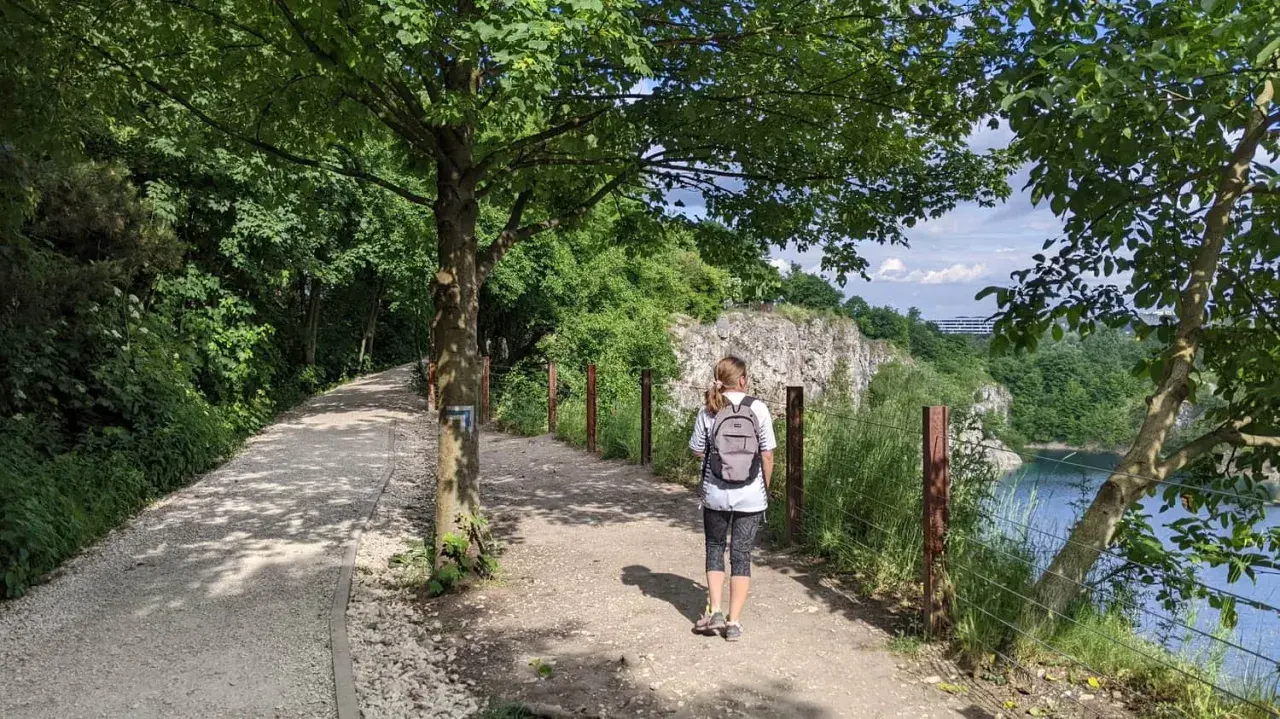 Ścieżka w kamieniołomie Liban, idealne miejsce, gdzie na spacer w Krakowie. Kobieta z plecakiem idzie w stronę skalistych zboczy.