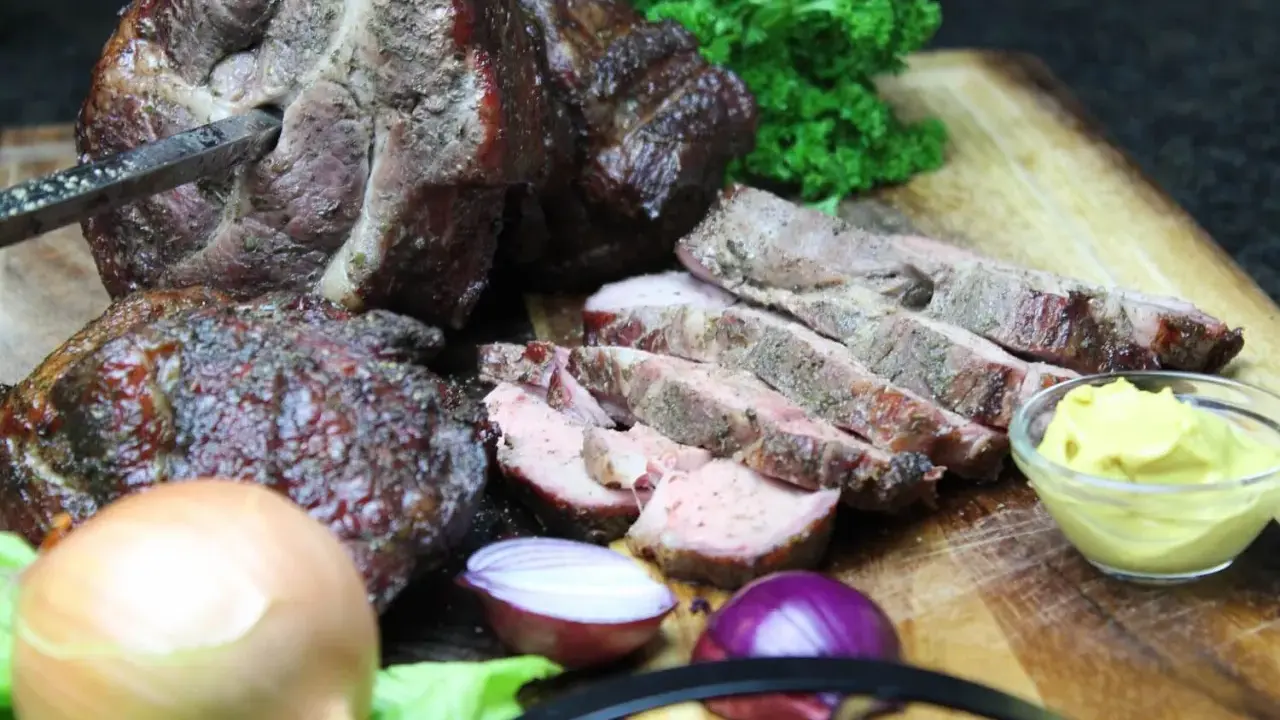 Saftiger Mutzbraten, frisch aufgeschnitten, mit Senf, Zwiebeln und Petersilie. Ein tolles Rezept für den Grill.