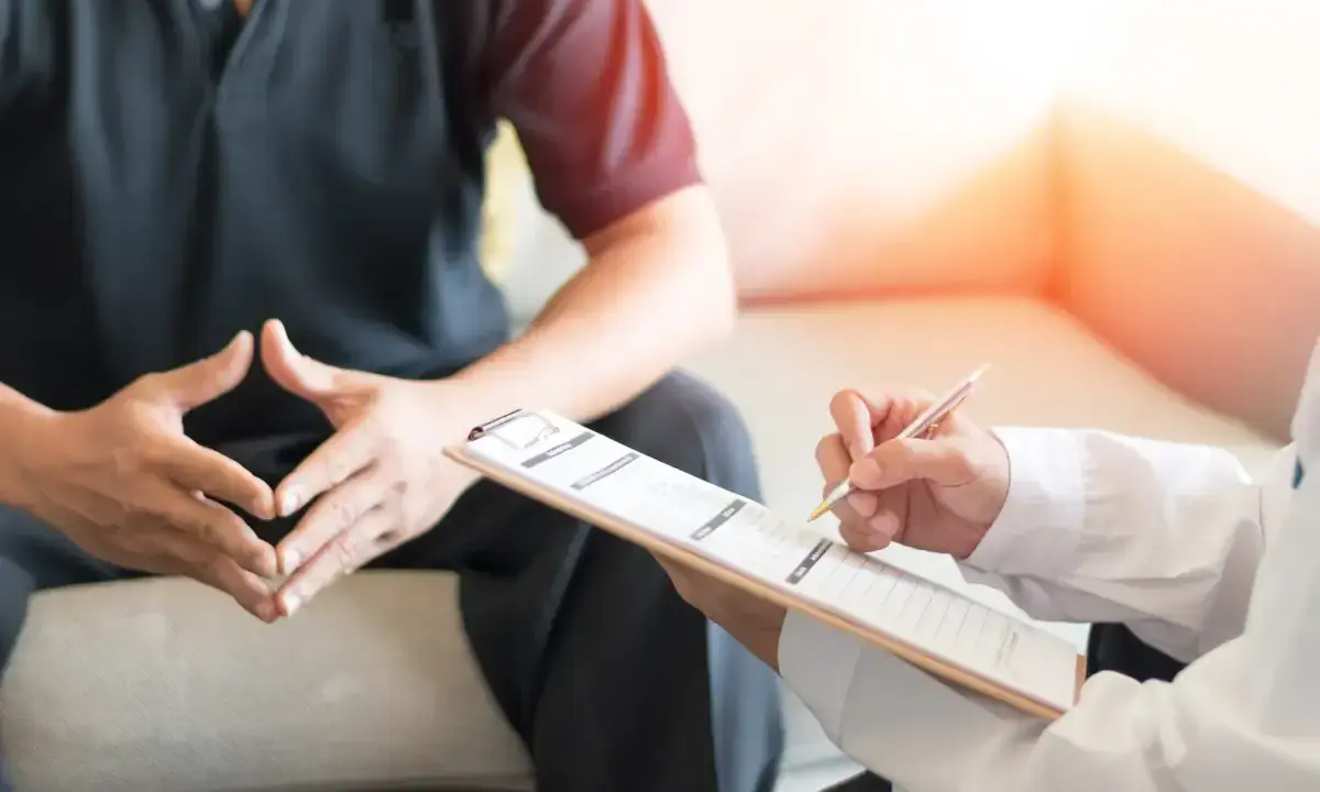 Lekarz notuje objawy pacjenta, który martwi się o swoją męską prostatę.