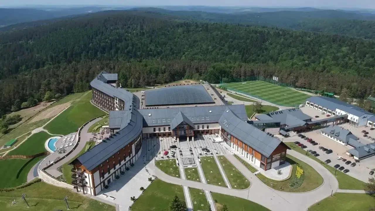 Hotel Arłamów, dzieło wizjonerskiego właściciela, w otoczeniu zielonych wzgórz. Kompleks hotelowy z basenem i boiskiem piłkarskim.