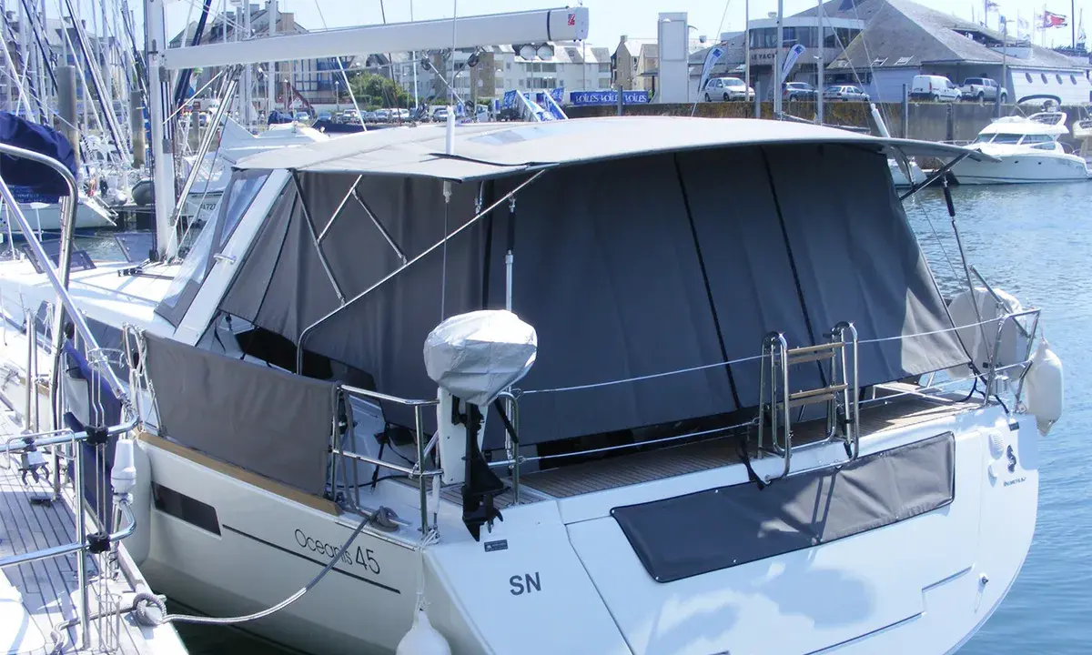 Bateau avec taud de soleil intégral, offrant une protection complète. La différence entre bimini et taud de soleil est claire : le taud couvre plus.