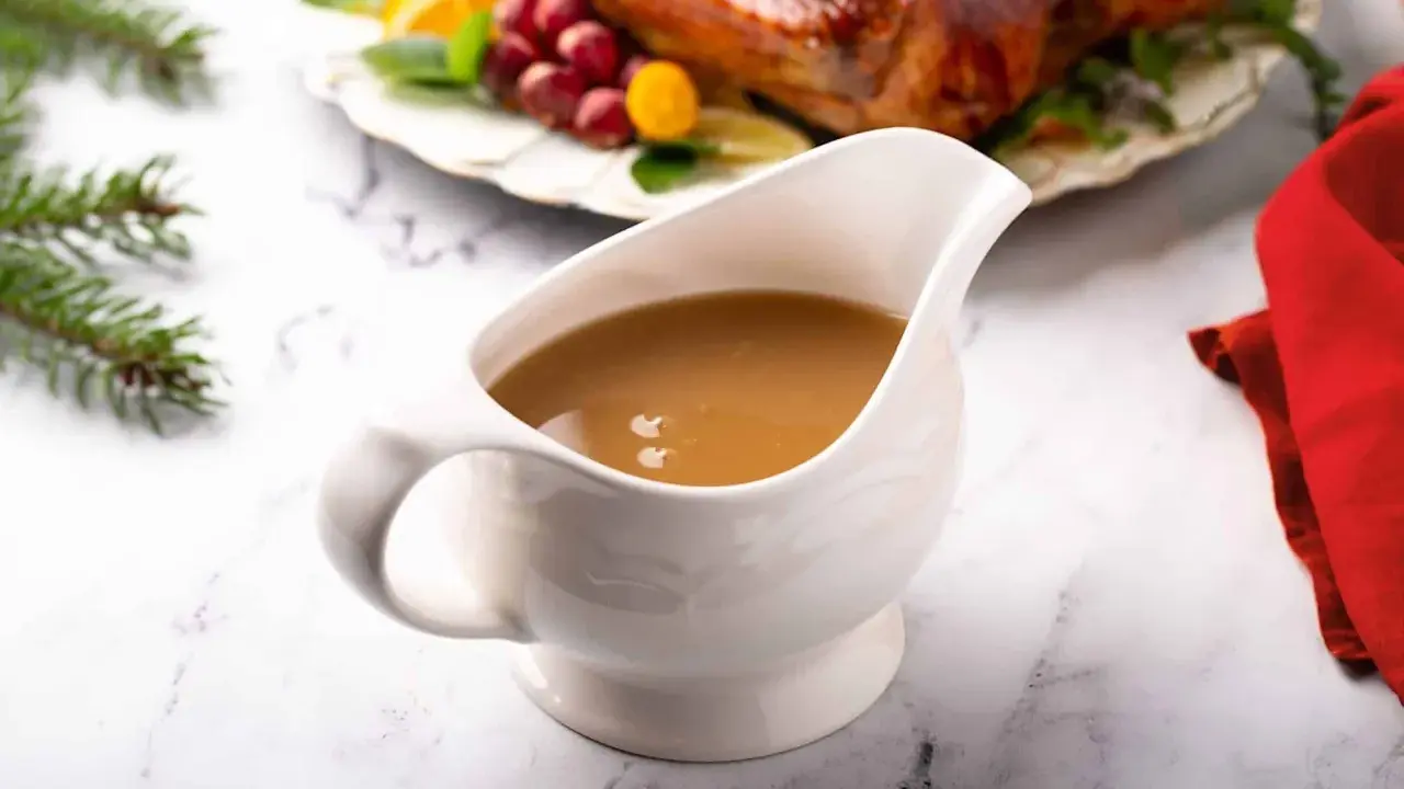 Saucière en porcelaine remplie d'une sauce pour dinde succulente, prête à accompagner le festin de Noël.