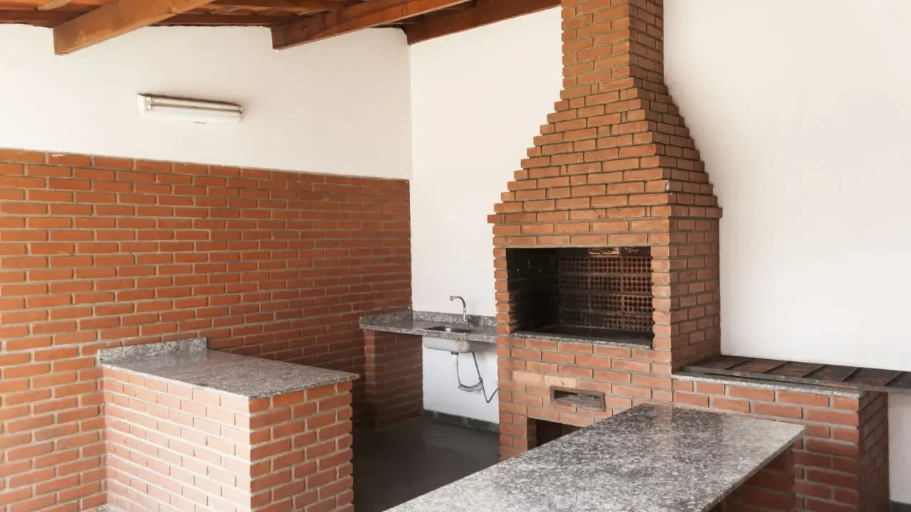 Solidny grill murowany z cegły, projekt z blatem i zlewem. Idealny na rodzinne spotkania.