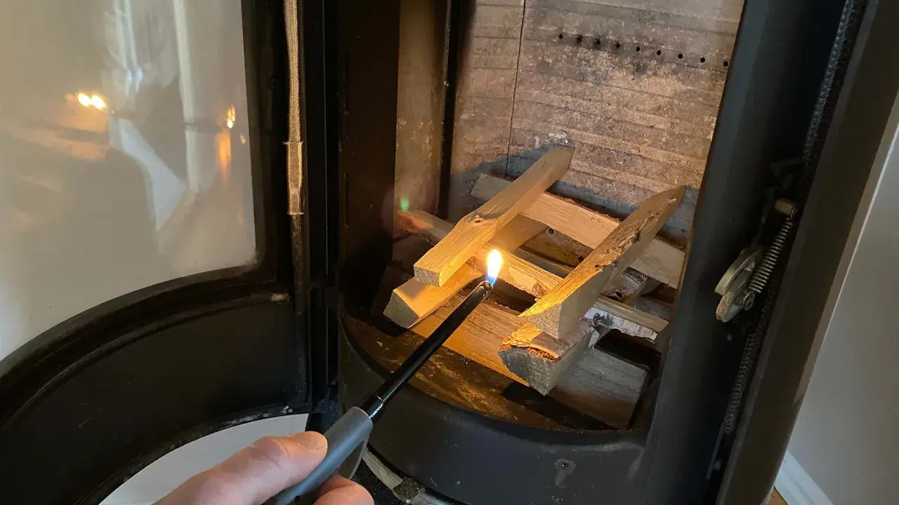 Tända en brasa i kaminen med tändare. Viktigt med brandskydd kamin för säkerhet.