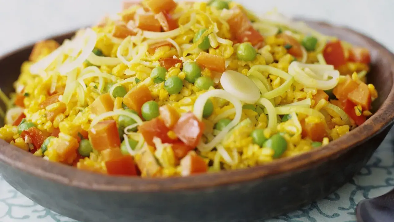 Bunter Reis mit Erbsen, Karotten und Lauchringen, inspiriert von Safran-Rezepten.