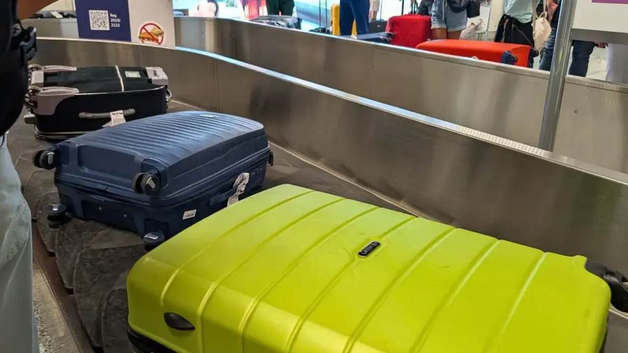Walizki na taśmie bagażowej. Zastanawiasz się, co zabrać na wakacje all inclusive? Oto inspiracja!
