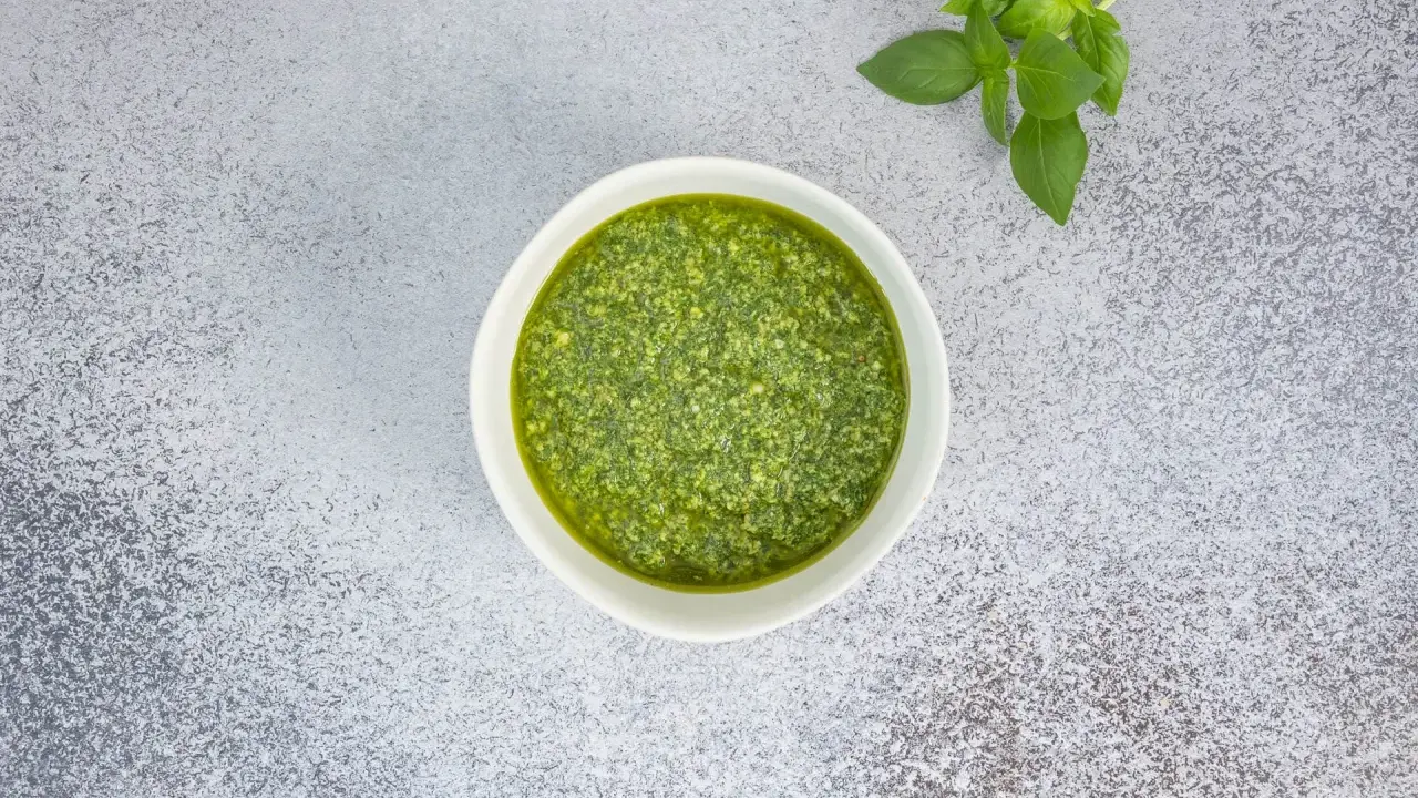 Frisches Basilikum und ein Schälchen mit selbstgemachtem Pesto. Ein einfaches Pesto Rezept für Pasta.