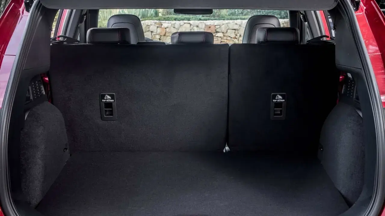 Maletero del Ford Kuga con asientos abatidos, listo para cargar equipaje o compras. Se aprecian los anclajes ISOFIX.