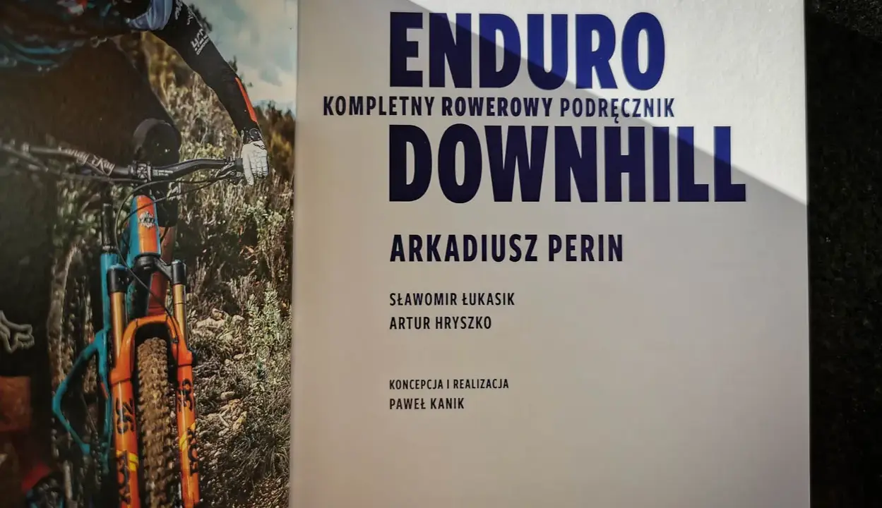 Książka "Enduro Kompletny Rowerowy Podręcznik Downhill" z rowerzystą w akcji. Dowiedz się, co to downhill!