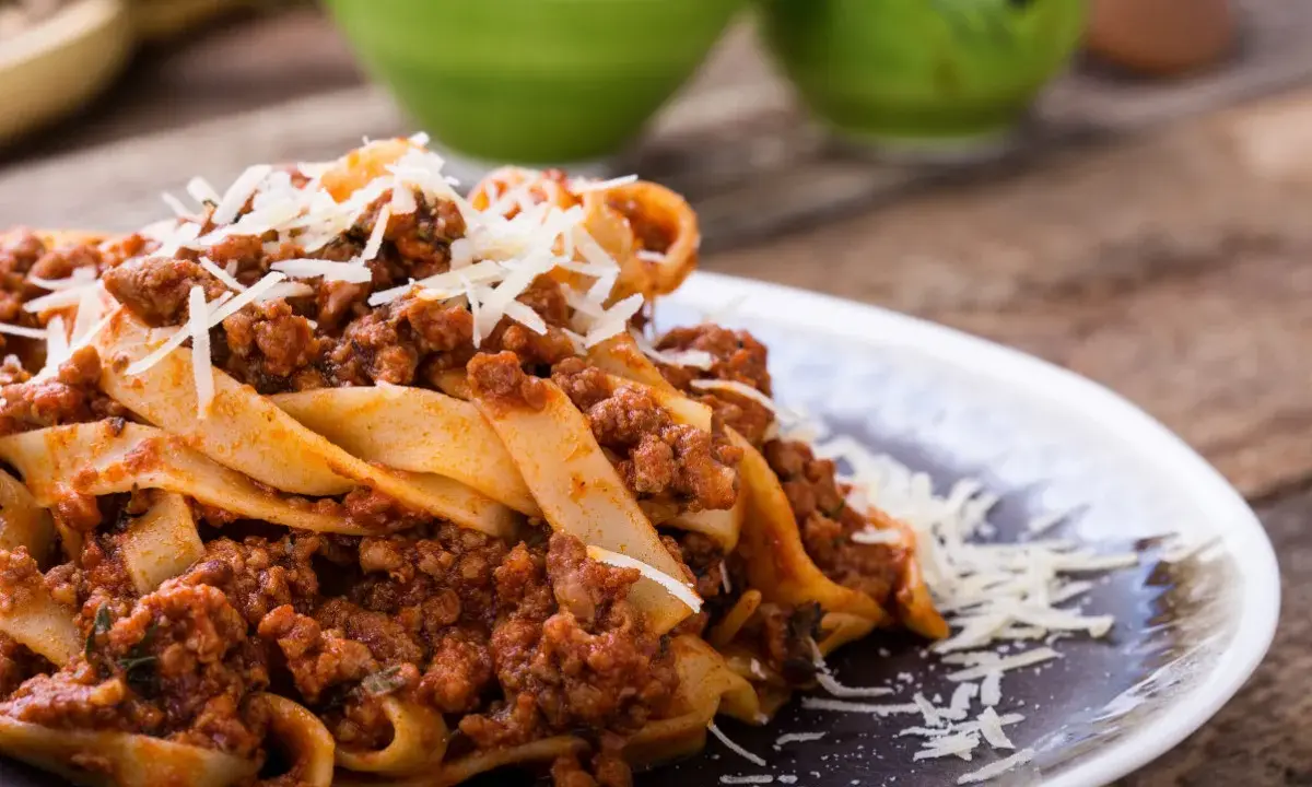 Pappardelle z bogatym sosem bolognese, posypane parmezanem. Pyszne mięso na spaghetti wprost z Włoch.