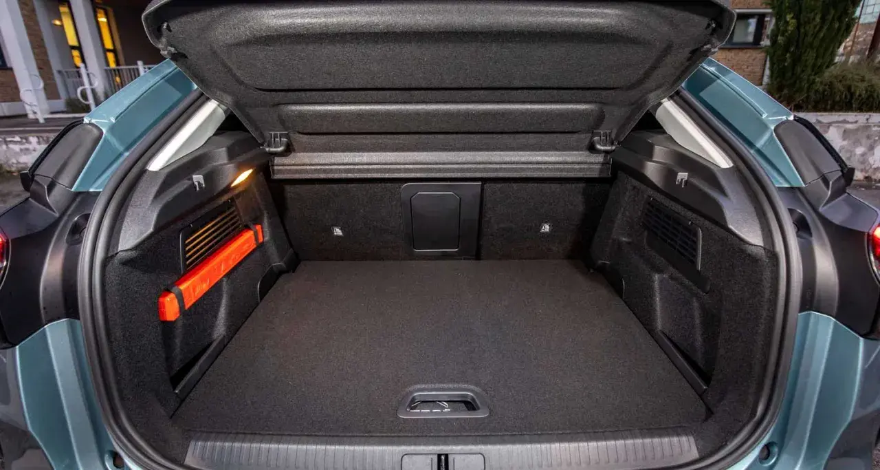 Maletero Citroën C4 vacío, con el triángulo de emergencia naranja visible a la izquierda. Espacio de carga listo para tus aventuras.