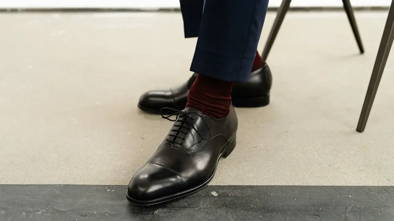 Eleganckie, czarne oksfordy to klasyczne rodzaje męskich butów. Wygodne, z bordowymi skarpetkami, idealne na formalne okazje.
