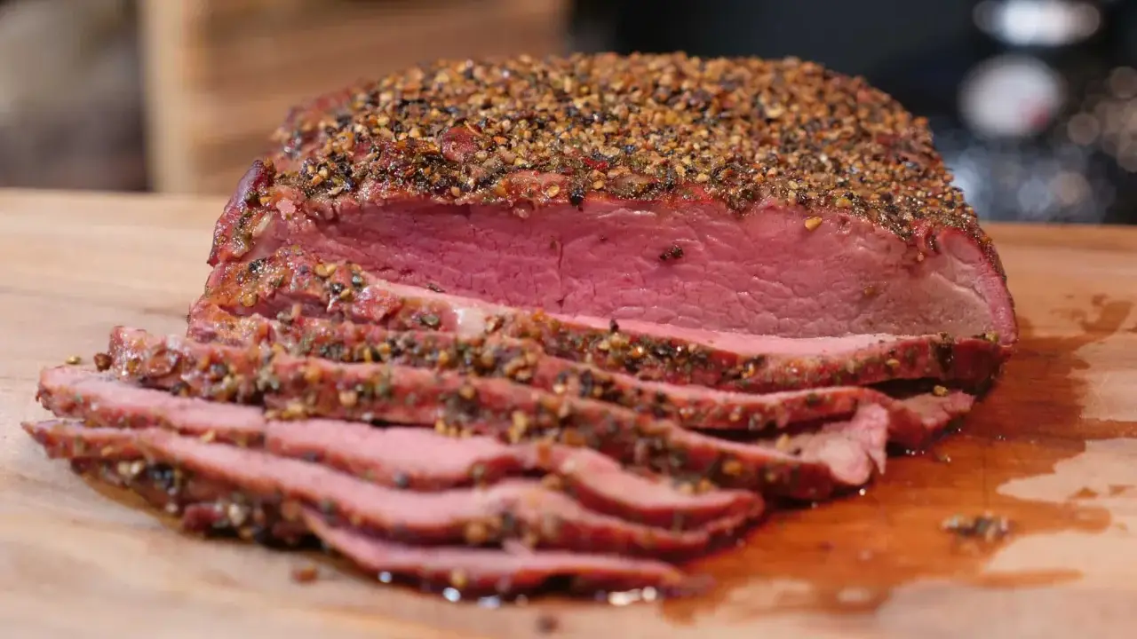 Perfekt gegrilltes Roastbeef mit kräftiger Gewürzkruste, saftig rosa geschnitten auf einem Holzbrett. Ein Genuss für jeden Grillmeister!