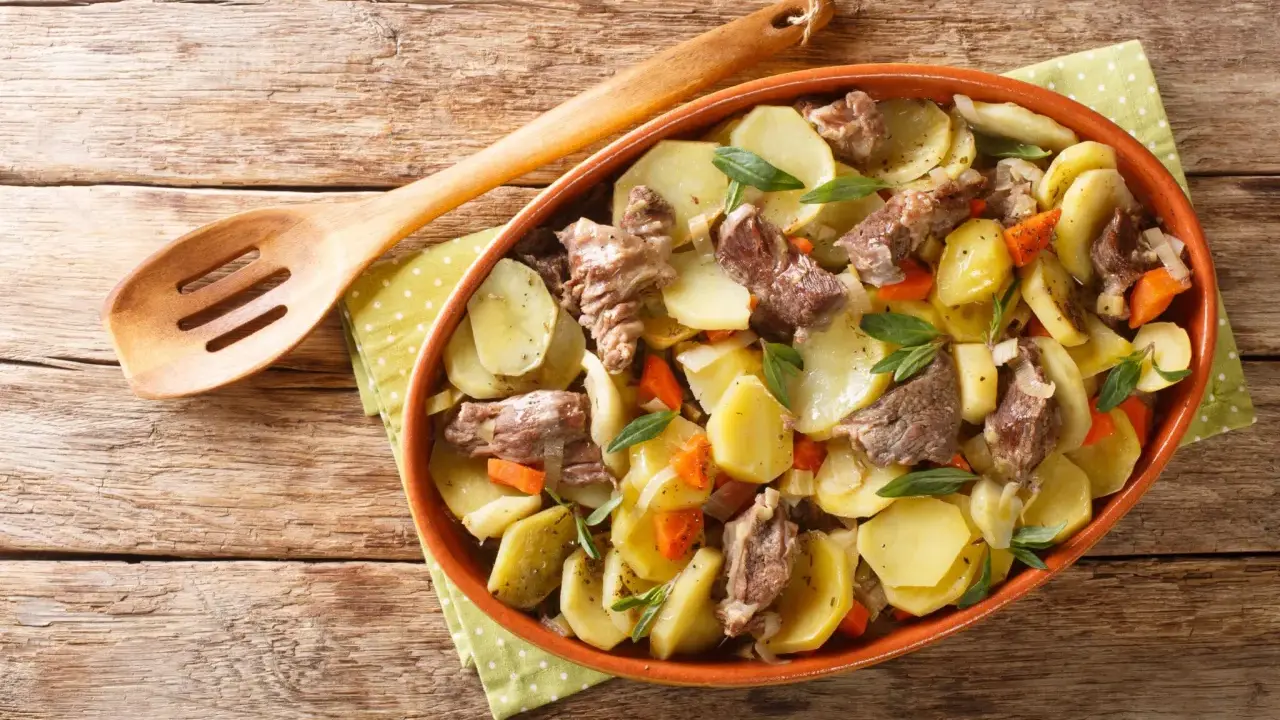 Un plat de pommes de terre et de viande mijotée, garni d'herbes fraîches, une spécialité alsace réconfortante.