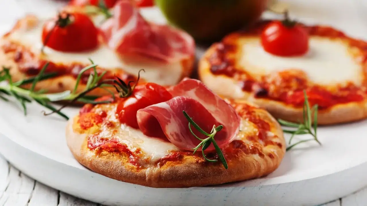 Pizzerinki z serka wiejskiego, pomidorkami koktajlowymi i szynką parmeńską, ozdobione rozmarynem.