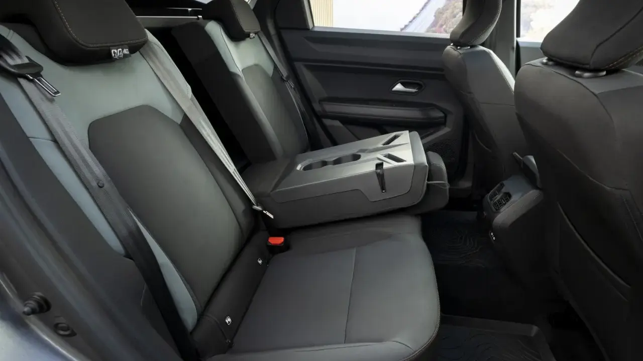 Interni Dacia Bigster: sedili posteriori in tessuto grigio e nero, bracciolo centrale ribaltabile con portabicchieri.