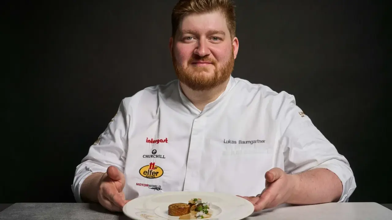 Lukas Baumgartner präsentiert ein Gericht, das an den Heiligen Laurentius erinnert, mit einer kunstvollen Garnitur.