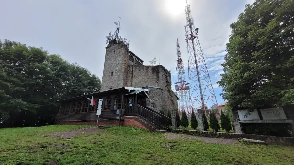 Kamienna wieża i maszty telekomunikacyjne na **chełmiec szczyt**. Drewniana przybudówka z flagami Polski.