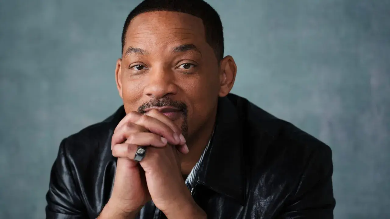 Will Smith, känd från många filmer och tv-program, sitter med händerna knäppta framför sig.