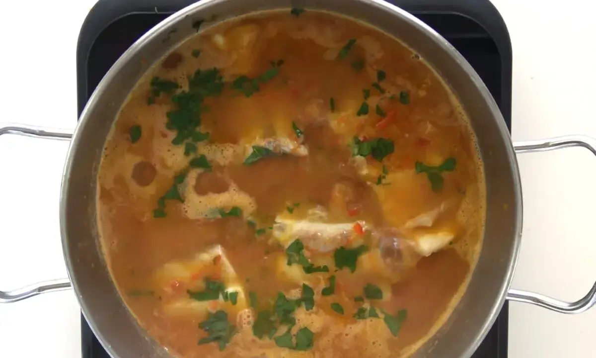Guiso de corvina burbujeante con perejil picado, listo para servir. ¡Perfecto para tus recetas de corvina guisada!