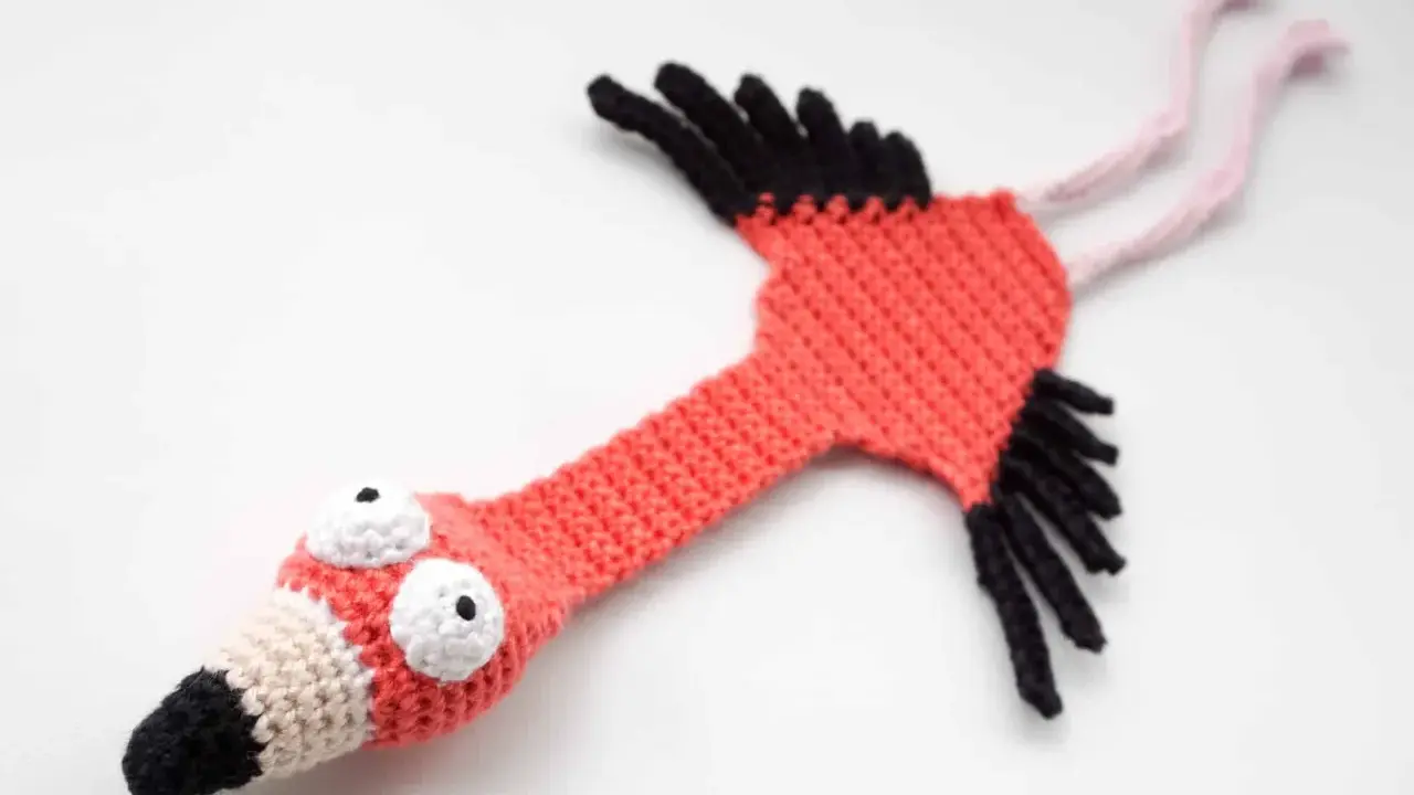 Flamenco amigurumi hecho a mano, con ojos saltones y pico bicolor. ¡Un patrón gratis para crear tu propio flamenco!