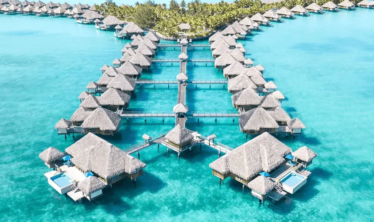 Bora Bora, gdzie jest? Rajskie domki na wodzie w turkusowej lagunie, otoczone palmami.