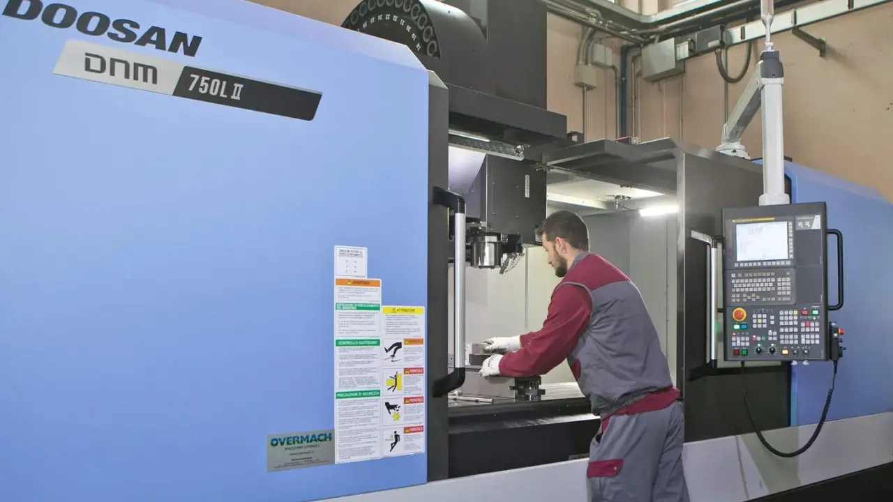 Operaio lavora su centro di lavoro CNC, strumento essenziale per il software progettazione e la produzione di precisione.