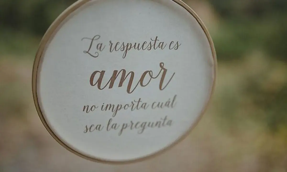 Bordado con "La respuesta es amor, no importa cuál sea la pregunta", ideal para frases cortas para felicitar bodas.