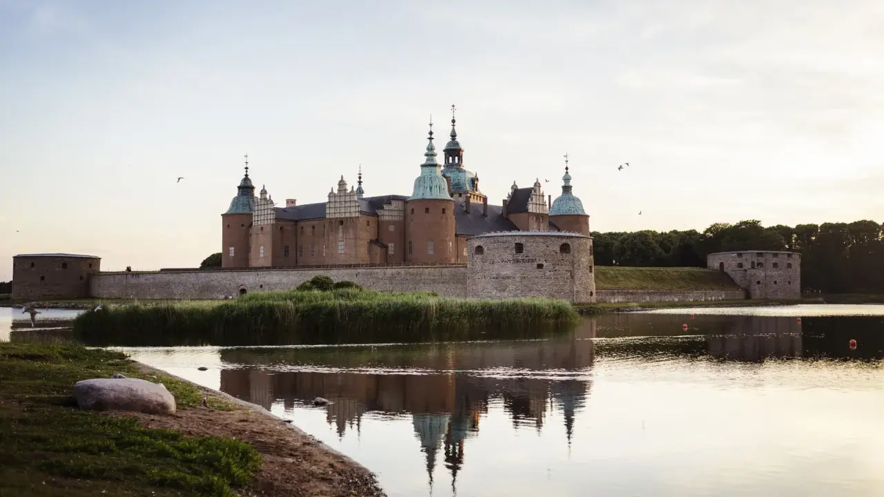 Kalmar Slott, ett populärt utflyktsmål, speglar sig i vattnet en stilla kväll.
