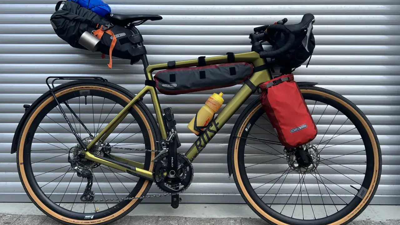 Gravelbike mit Packtaschen für Bikepacking. Das Zelt ist im Satteltaschen-Setup verstaut, bereit für das nächste Abenteuer.