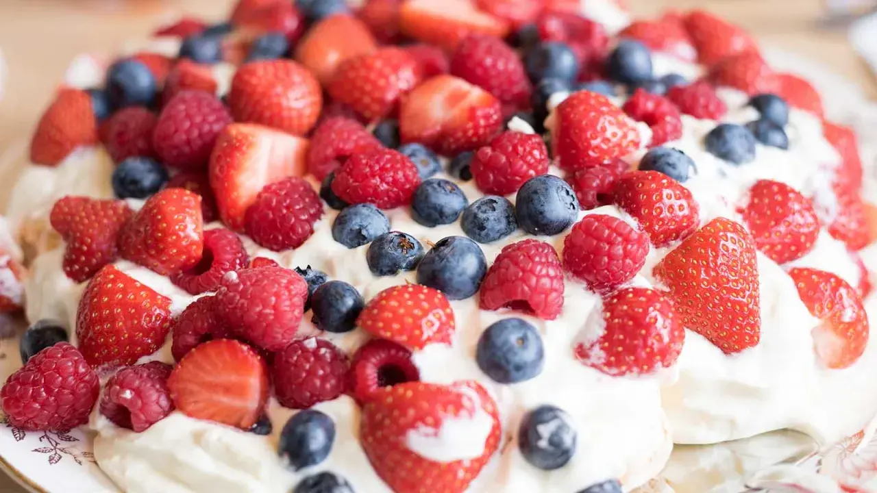 En härlig pavlova med vispgrädde och massor av färska bär. Ett perfekt pavlova recept för sommaren!
