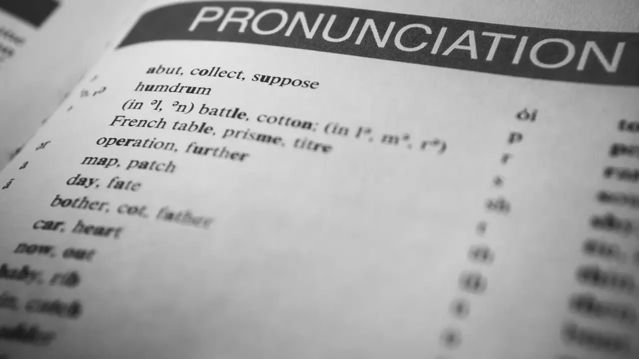 Otwarta książka z hasłem "PRONUNCIATION". Lista słów i symboli fonetycznych pokazuje, czy angielski jest trudny.