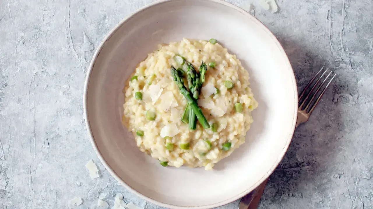 Cremiges Spargel-Erbsen-Risotto, garniert mit frischem Spargel und Parmesan. Ein Beweis für die besten Risotto Rezepte.