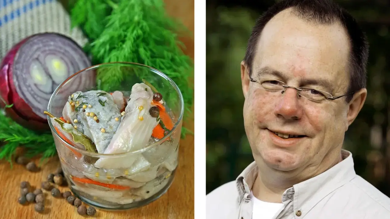 En man ler mot kameran bredvid en skål med inlagd sill, en klassisk del av påskbord mat.