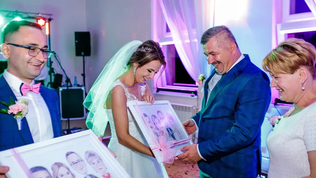 Para młoda z uśmiechem odbiera portrety. Elegancki ślub w stylu mafii, gdzie każdy detal jest dopracowany.