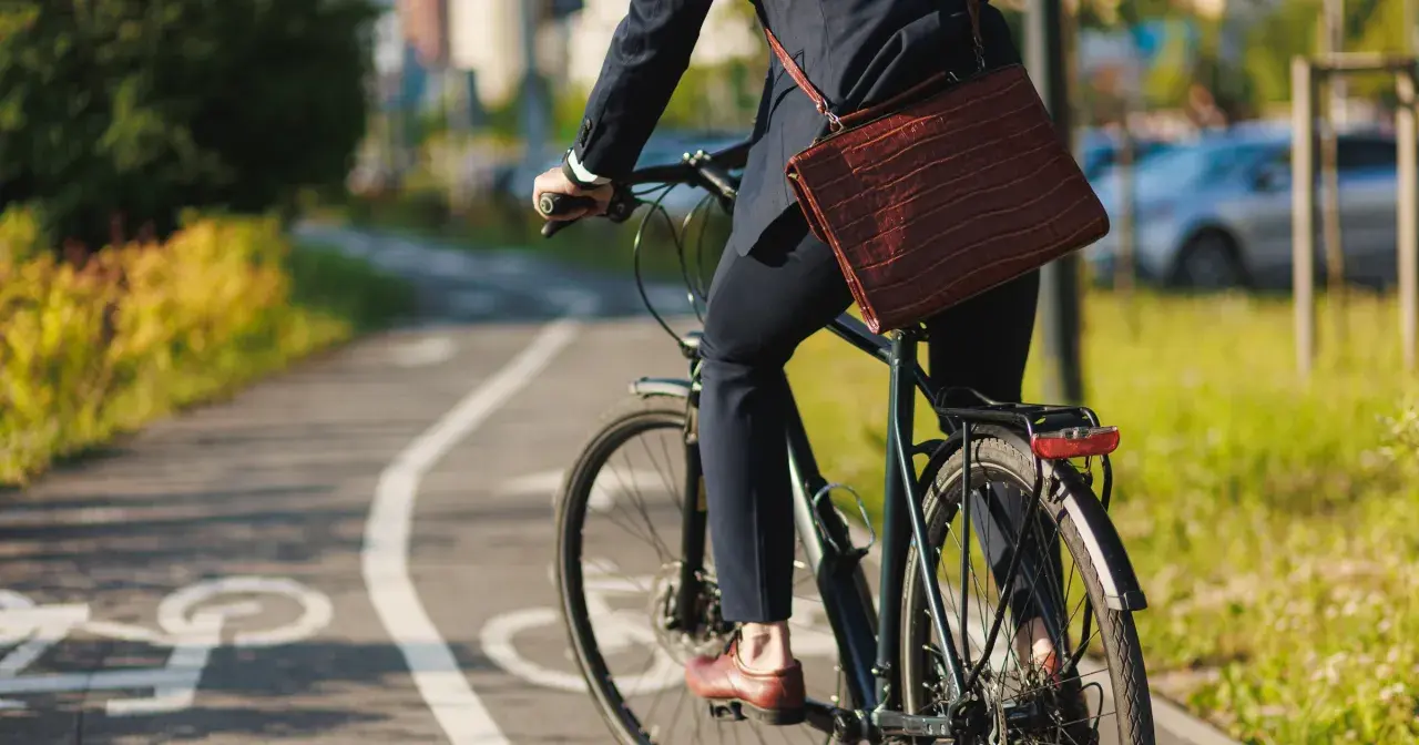 Biznesmen na rowerze, jadący ścieżką rowerową. Zastanawia się, ile promili na rowerze jest dopuszczalne, by bezpiecznie dotrzeć do celu.