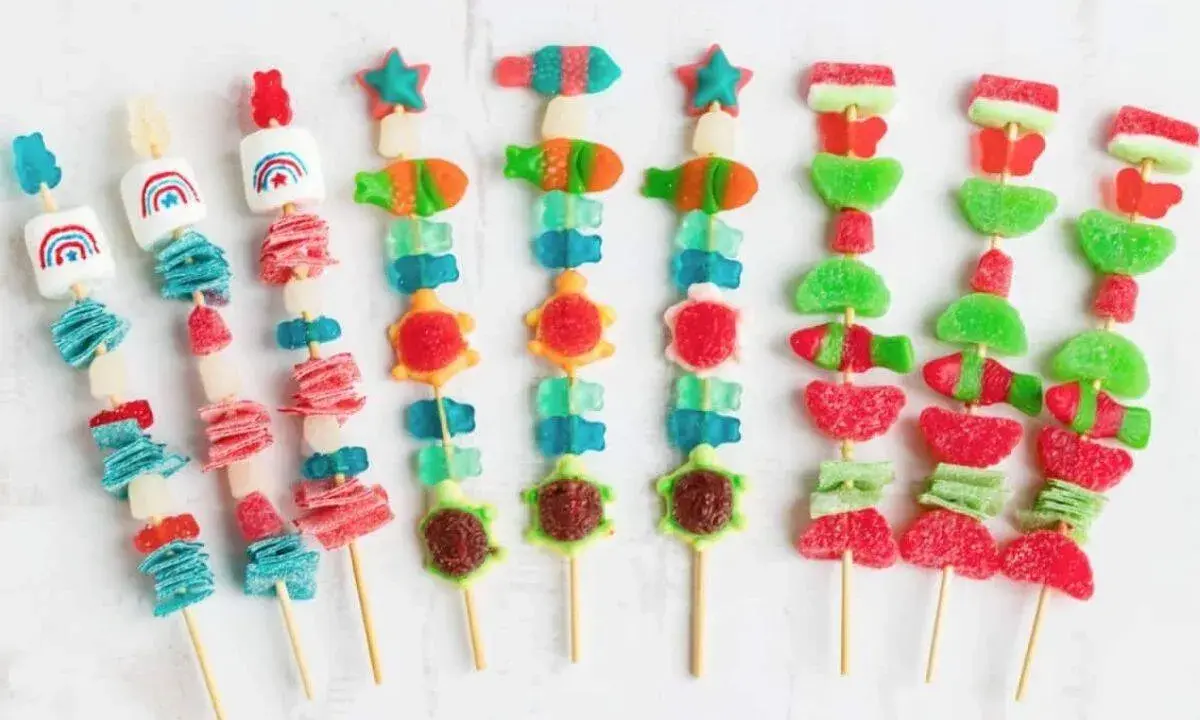Brochetas de chuches con formas de animales y arcoíris, listas para envolver y disfrutar.