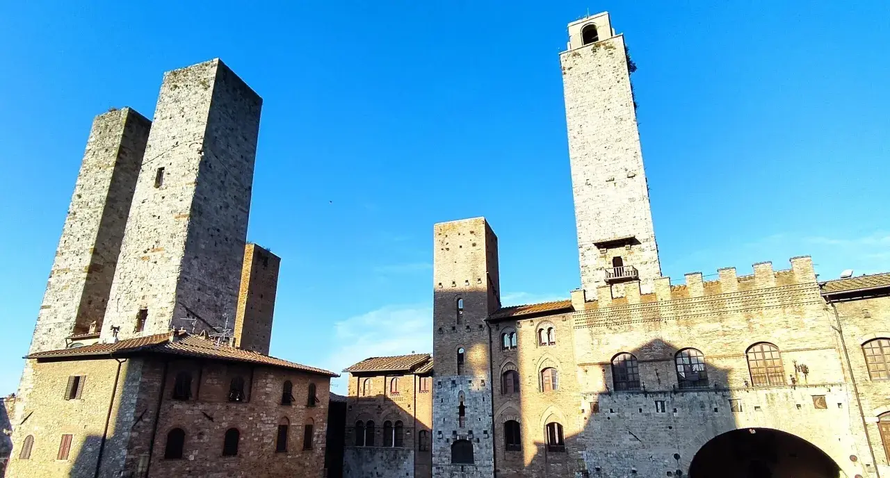 Wieże średniowiecznego miasta San Gimignano wznoszą się dumnie pod błękitnym niebem.